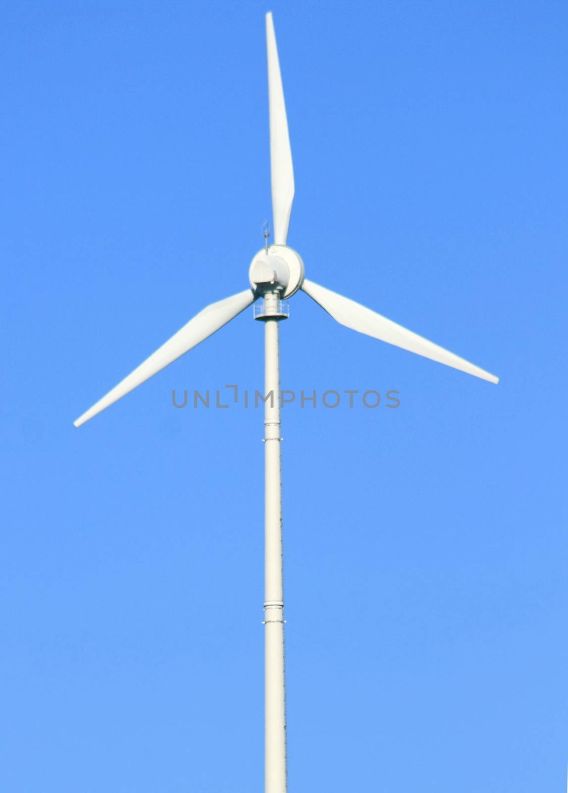 Wind turbine to generate electricity with blue sky in the background  Windrad zur Stromerzeugung mit blauem Himmel im Hintergrund