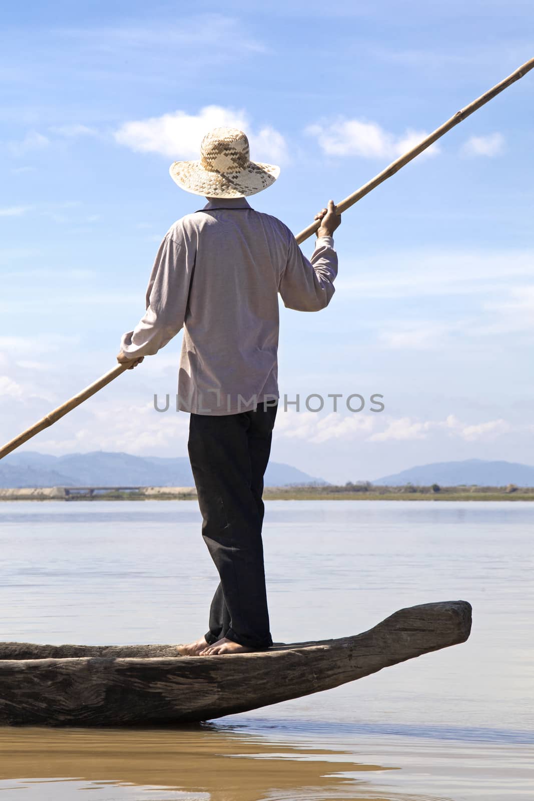Dak Lak, VIETNAM - JANUARY 6, 2015 - Man pushing a boat with a long pole