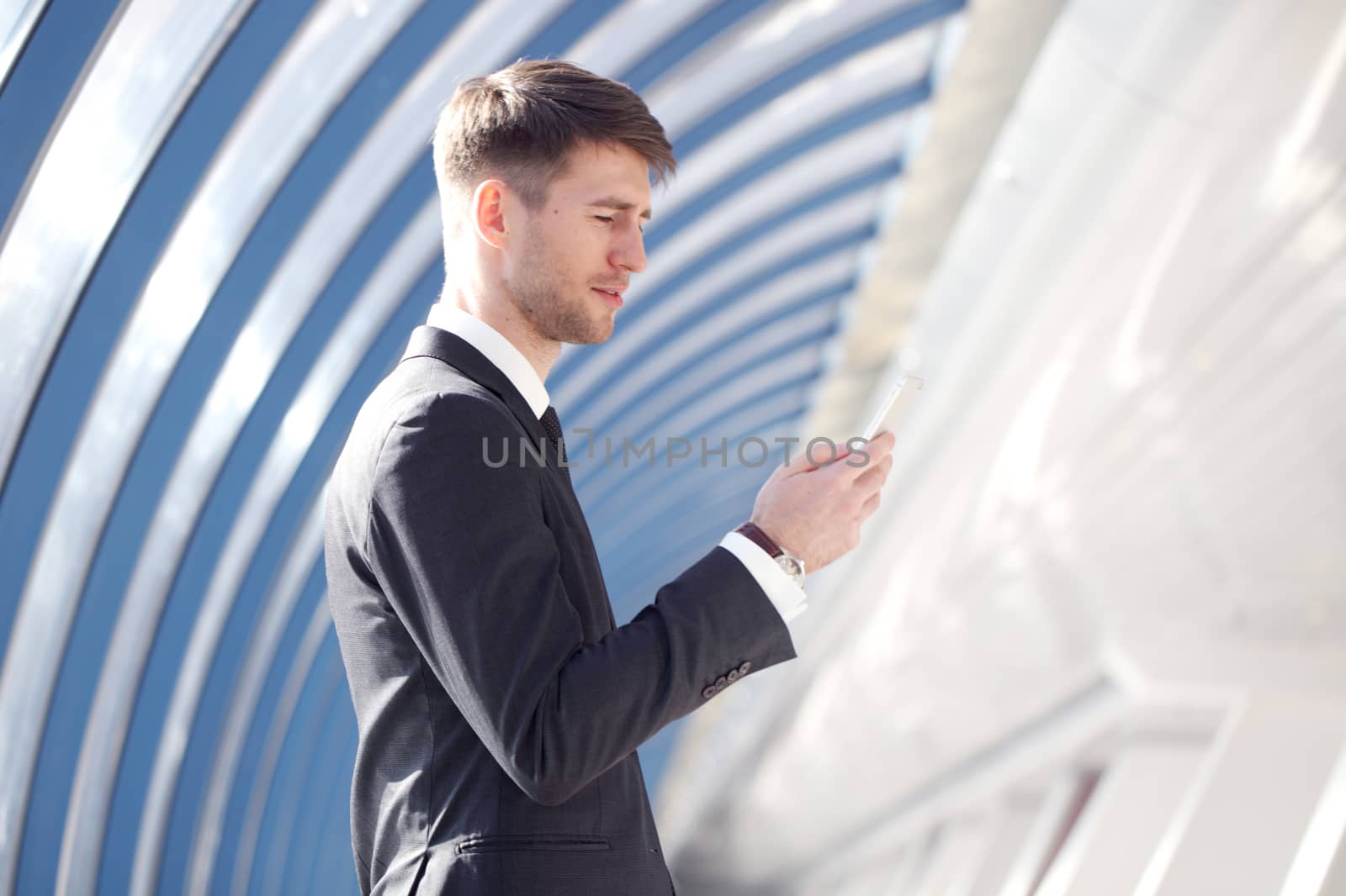 Businessman looking at his smartphone in modern building