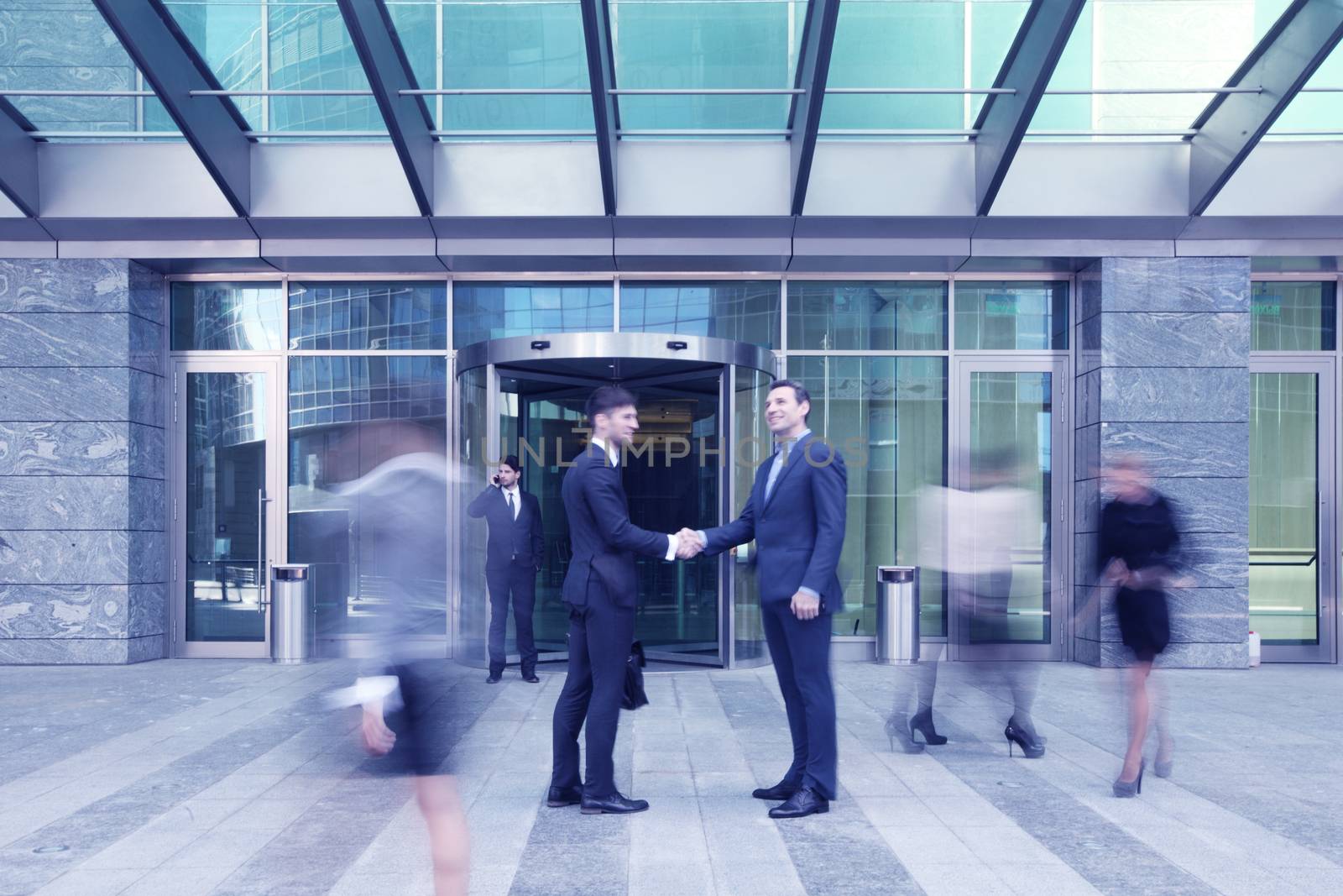 Business people shaking hands, finishing up a meeting outside office