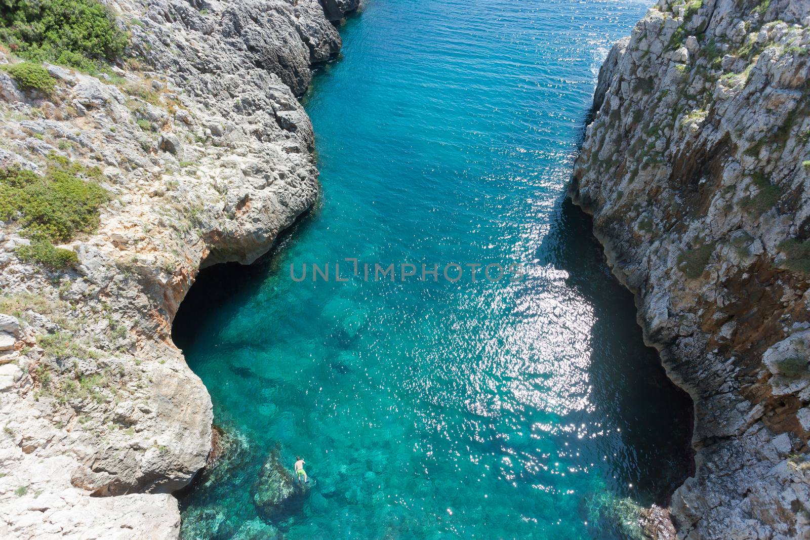 Apulia, Leuca, Italy, Grotto of Ciolo - A man swimming at Grotto Ciolo