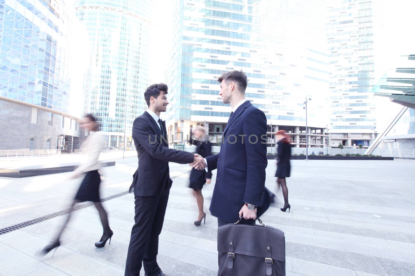 Business people shaking hands, finishing up a meeting outside office