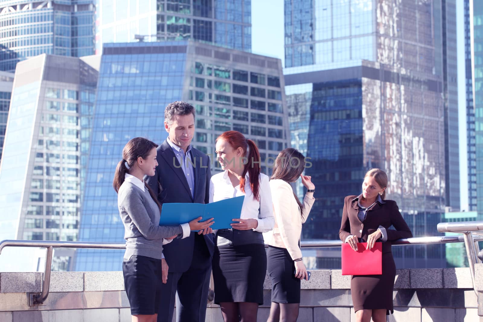 Portrait of business team outside office on skyscrapers background