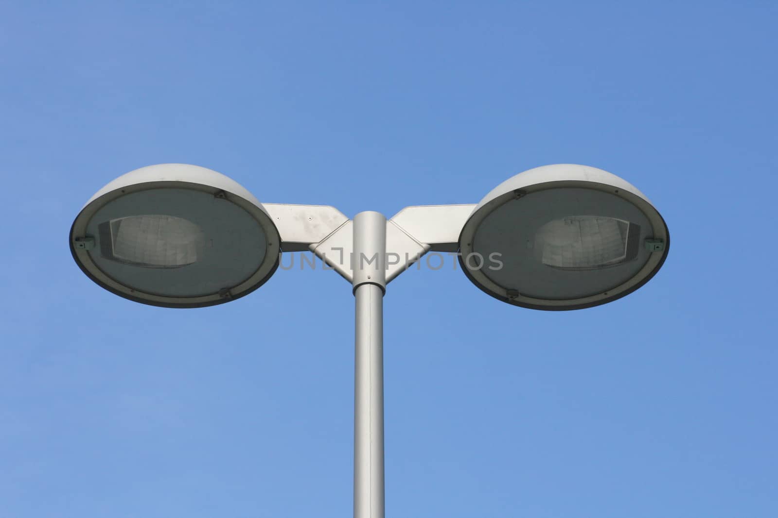 Street light with two lamps, blue sky in the background  Stra�enlaterne mit zwei Strahlern,blauer Himmel im Hintergrund