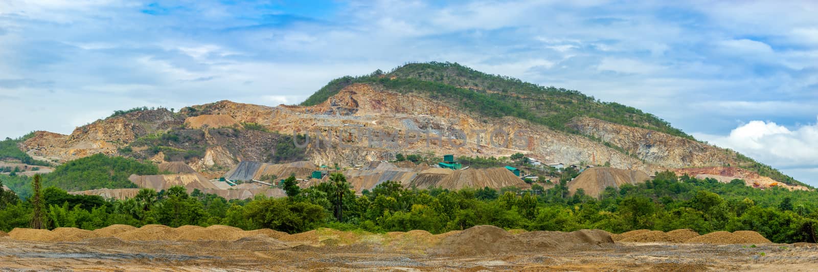 Panoramic of limestone quarry or mining industry on the mountain and blue sky. Concept of global warming.