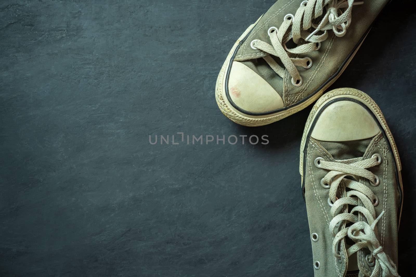 Top view dirty sneaker on black cement floor. Copy space for tex by SaitanSainam