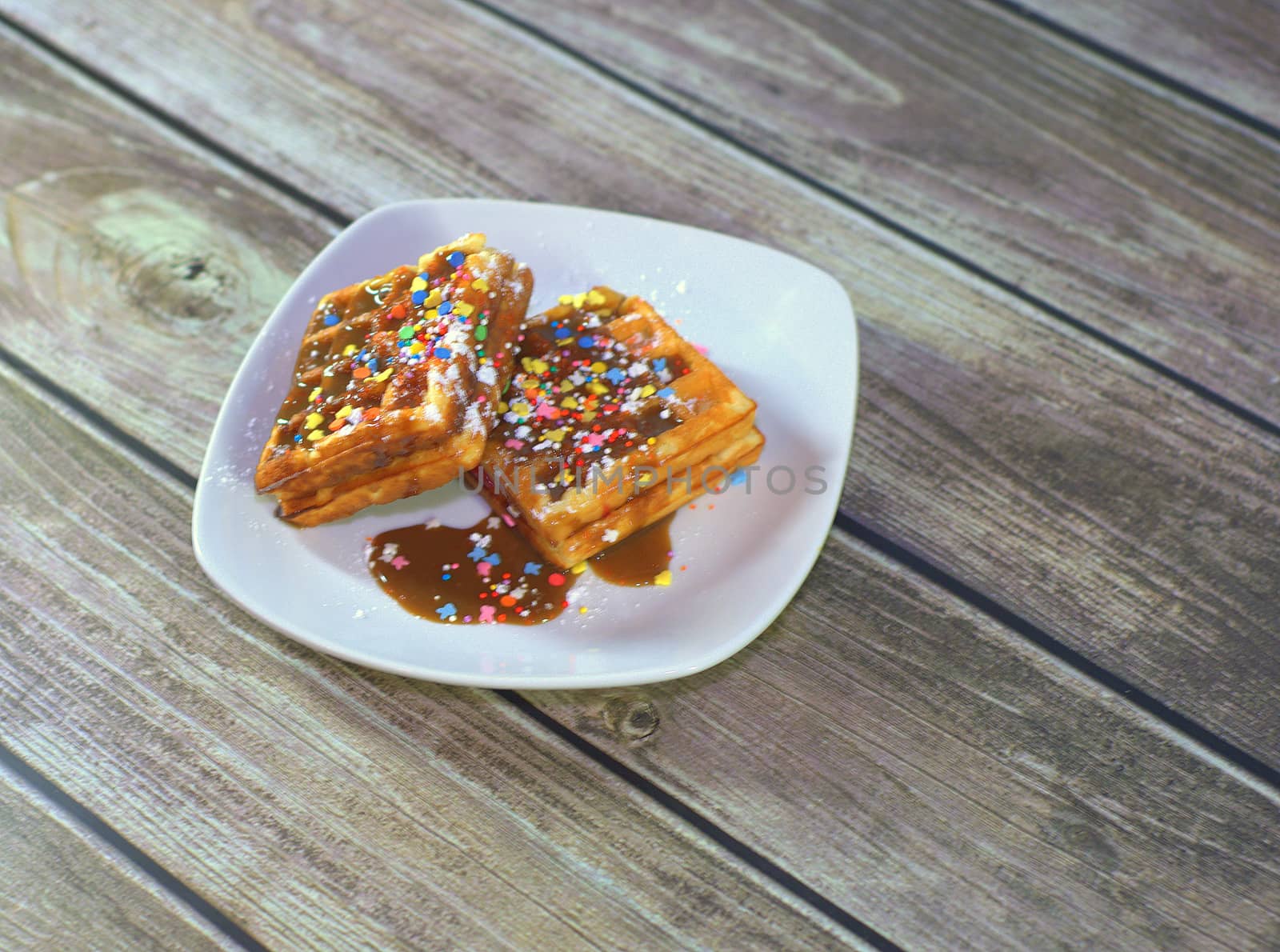 Plate with two Viennese waffles in icing and topped.