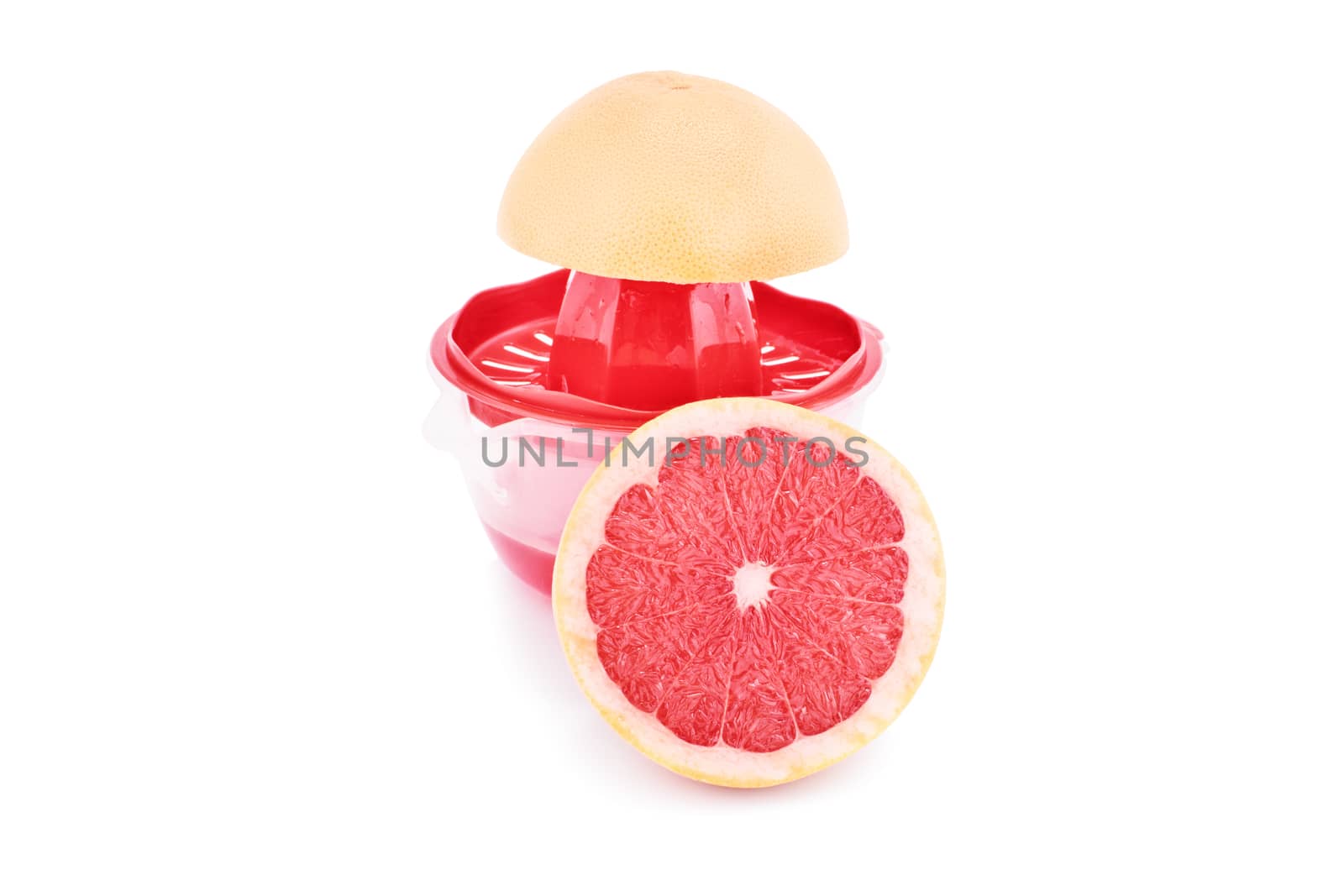 Half filled squeezer with citrus slices, isolated on white background. Making fresh grapefruit juice.