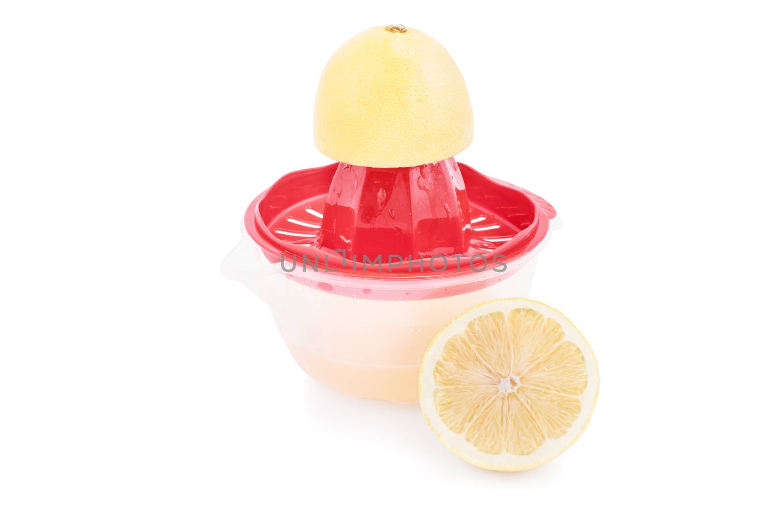 Half filled squeezer with lemon juice and slices isolated on white background