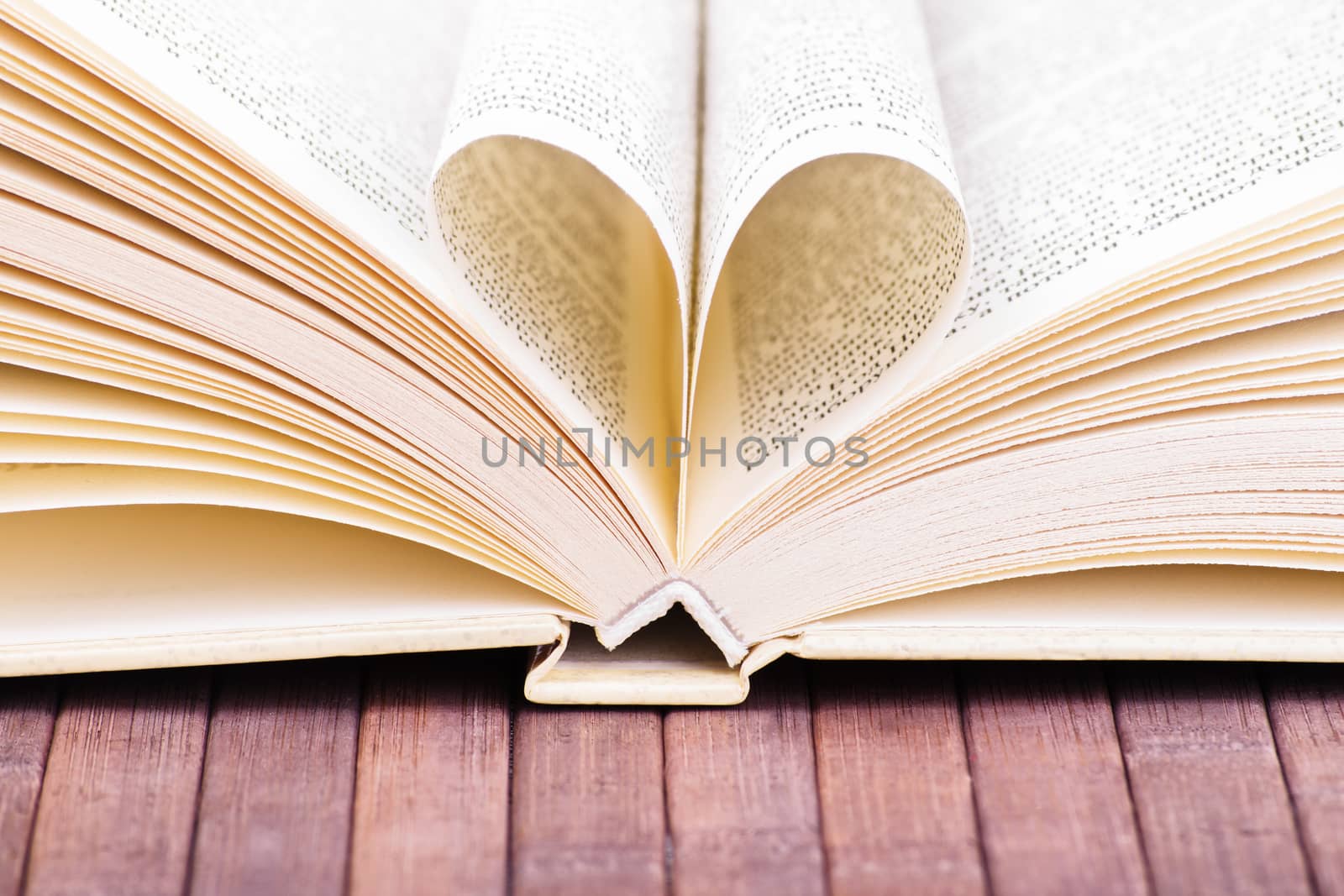 Close-up shot of an open book with two pages forming a heart