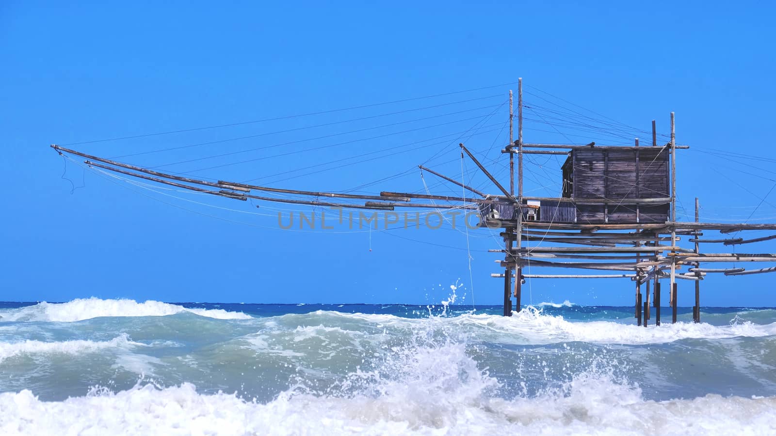 Trabocchi coast in Abruzzo with big waves on rough sea - Italy - a trabucco is an old fishing machines famous in south italy sea by LucaLorenzelli