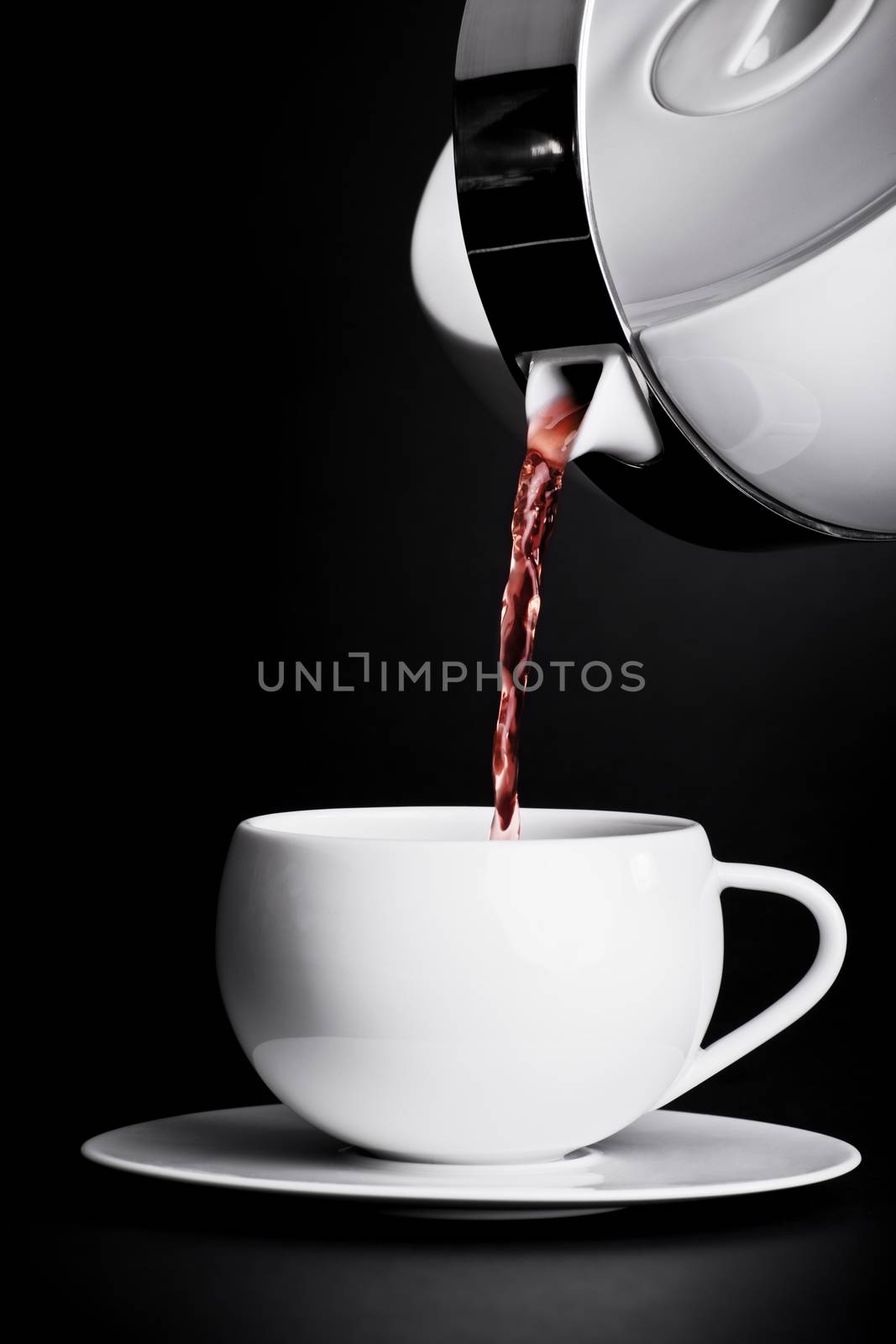Pouring tea on black background by Mendelex