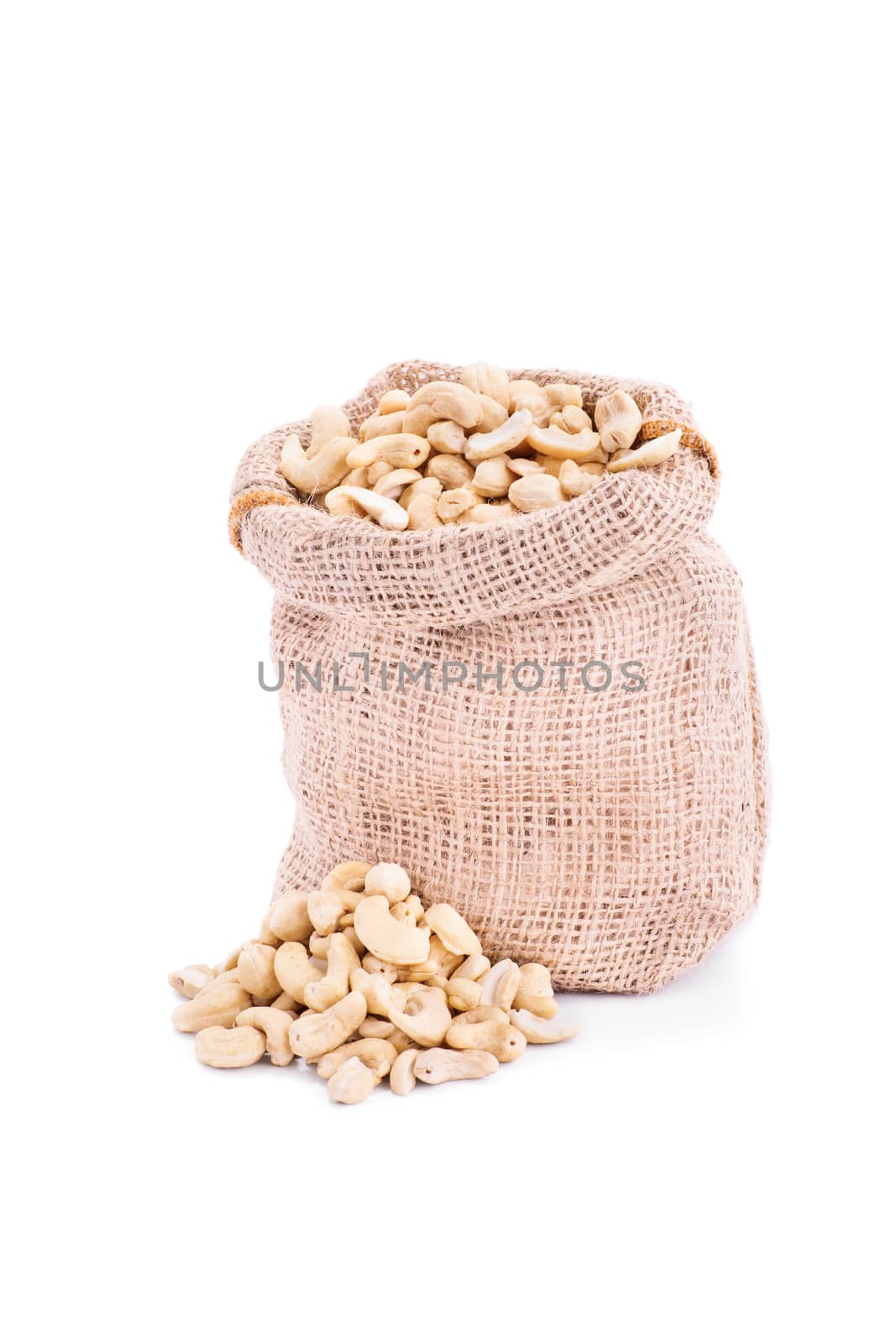 Small burlap sack of fresh cashews, isolated on white background.