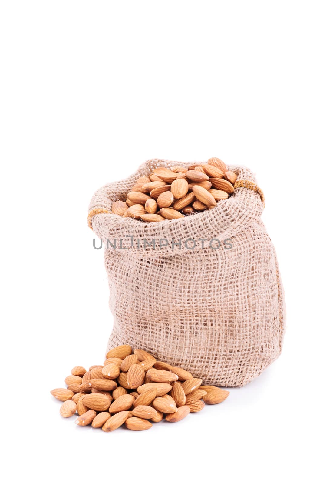 Close up shot of a small burlap sack of fresh almonds, isolated on white background.