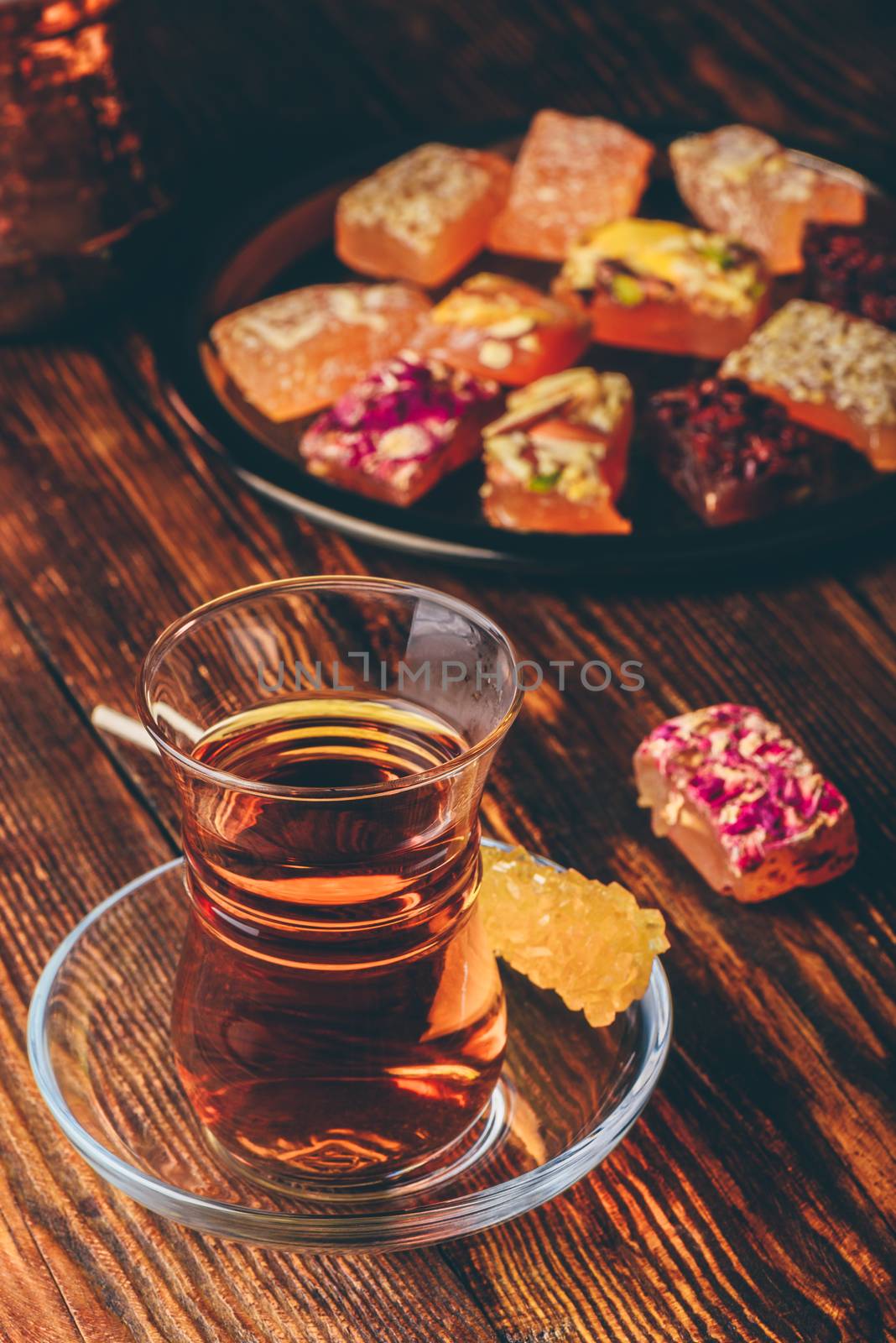 Tea in armudu glass with oriental delight rahat lokum over wooden surface