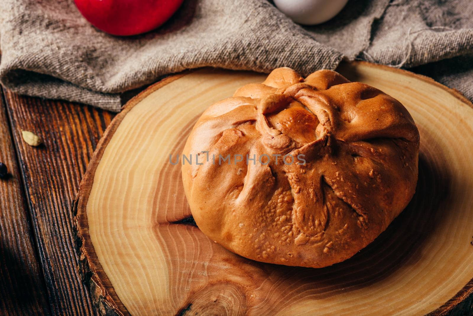 Rustic breakfast with traditional tatar pastry elesh, herbal tea in metal mug, apple and boiled eggs over dark wooden surface