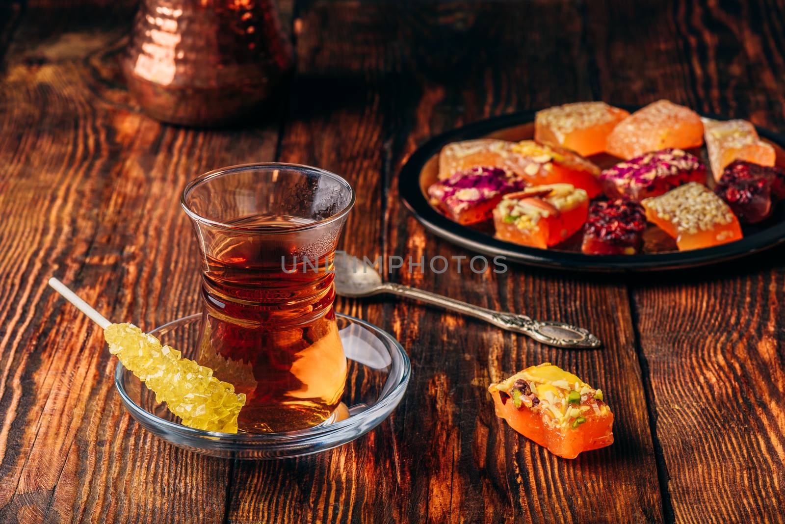 Tea in armudu glass with oriental delight rahat lokum over wooden surface