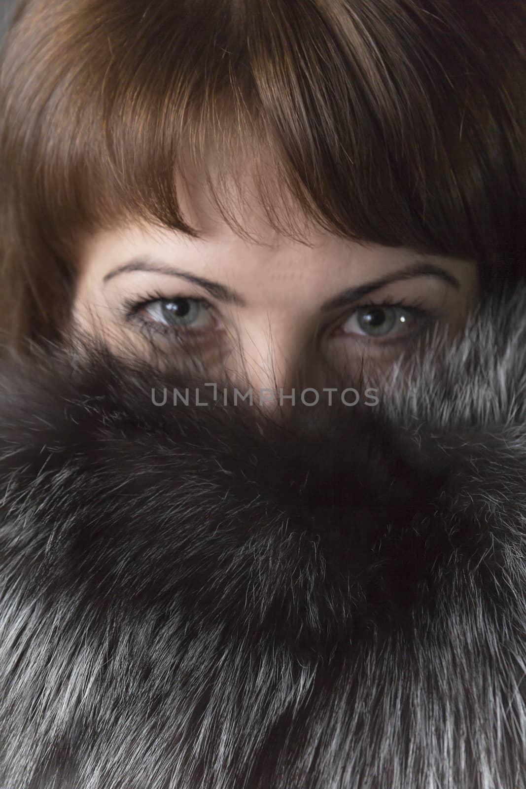 Expressive eyes of a young girl in natural fur collar