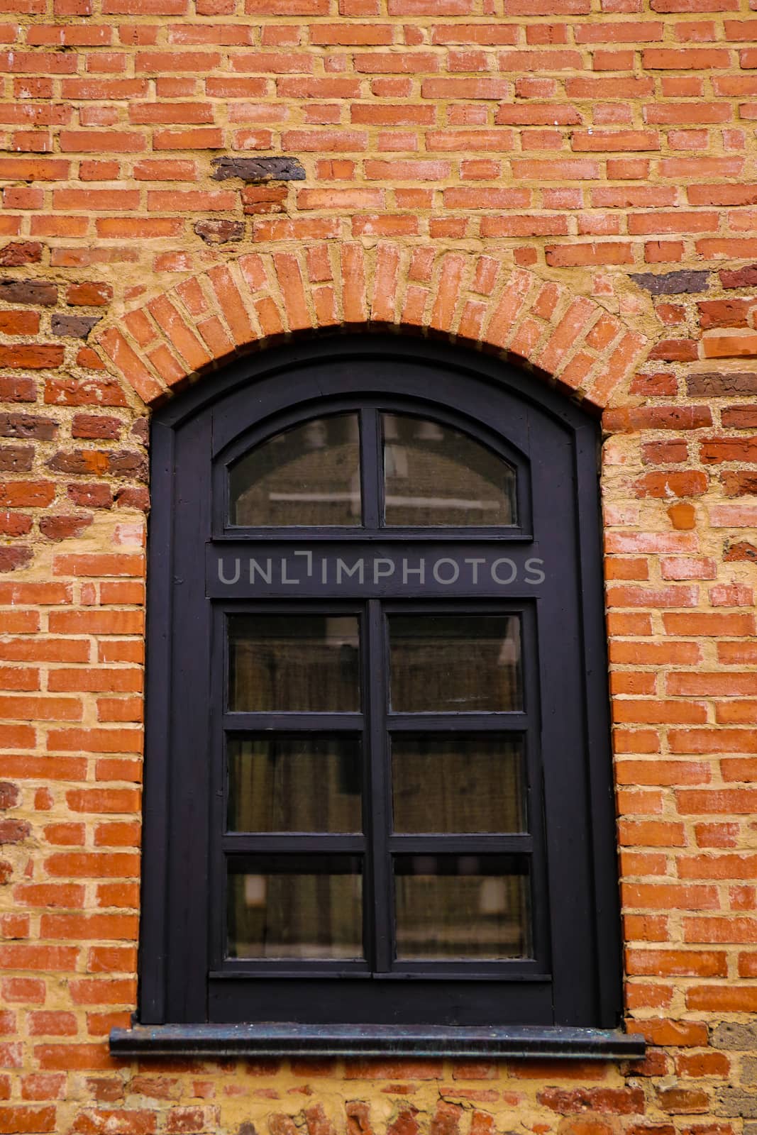 Old window on the background of a yellow brick wall