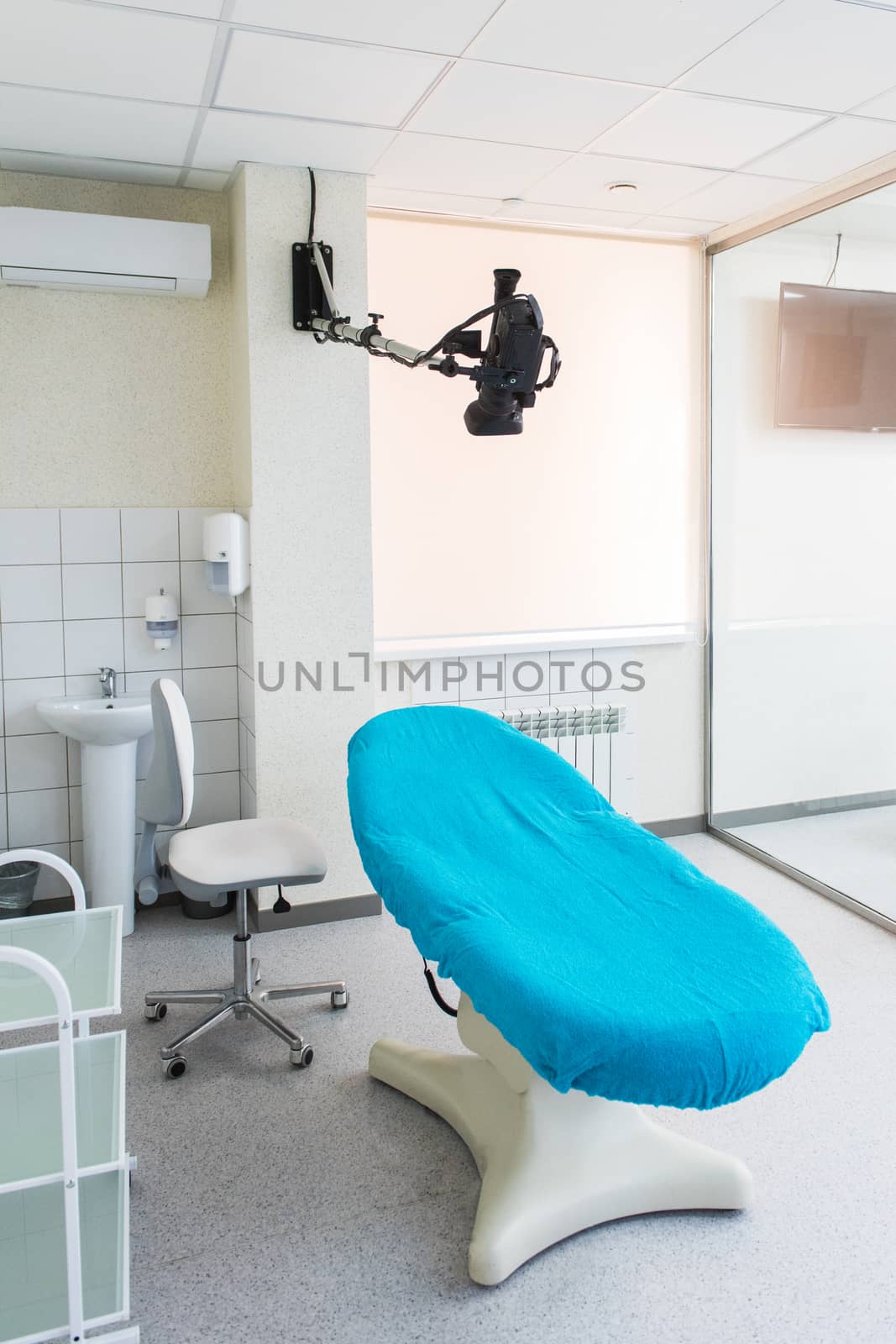 Medical chair and video camera for record or doctor's teleconference, empty cabinet