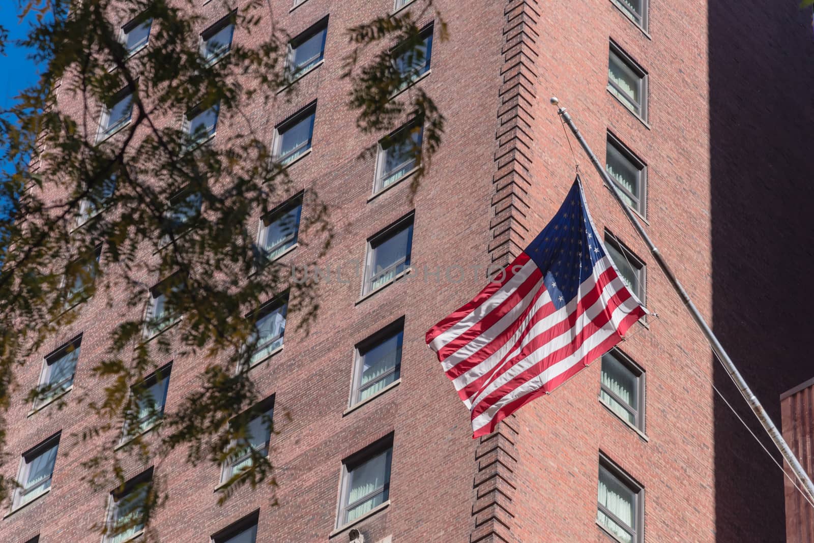 Upward view waving American flag on federal buildings in downtown Chicago by trongnguyen