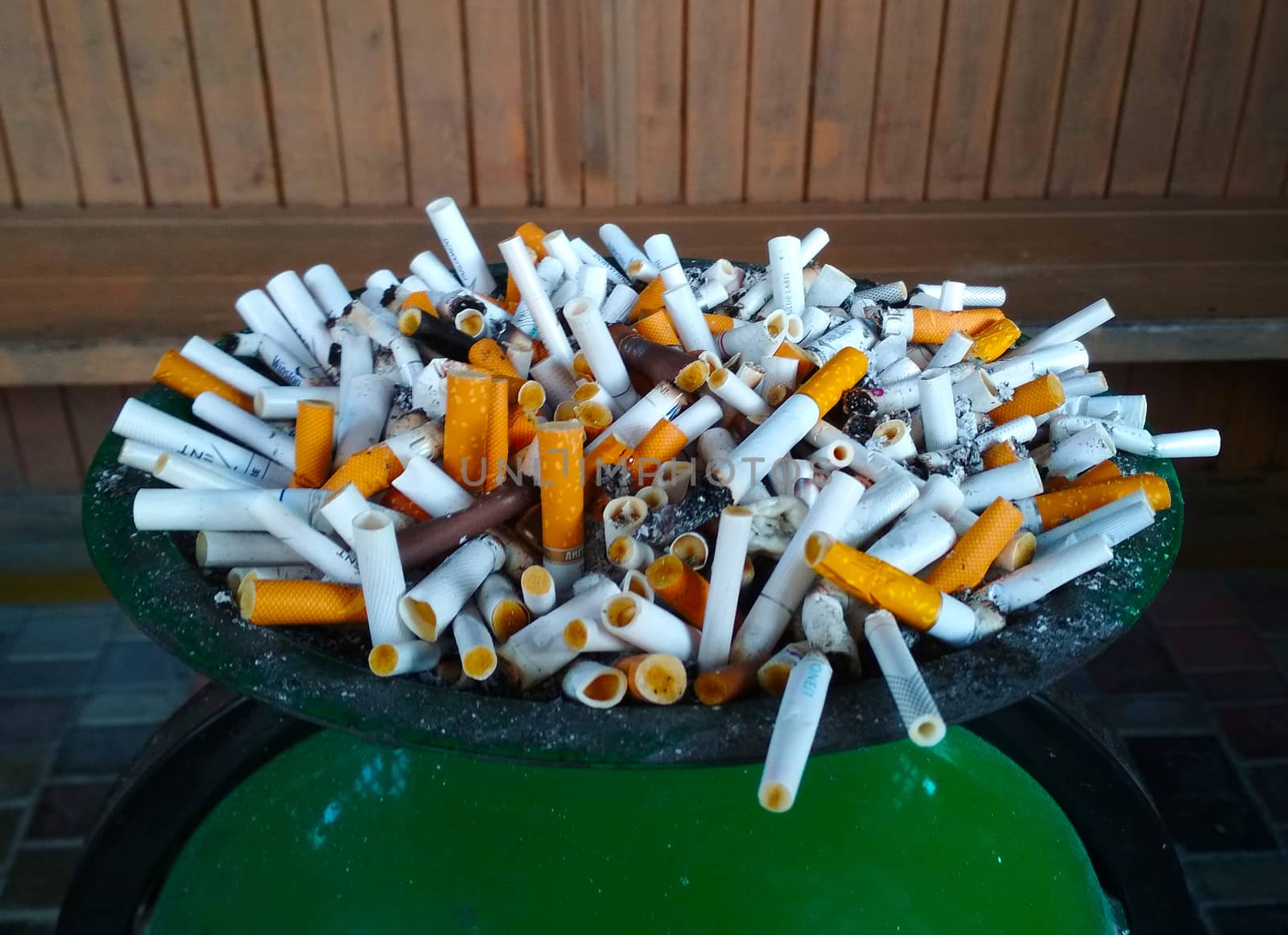 Large ashtray with cigarette butts of different colors. by Igor2006