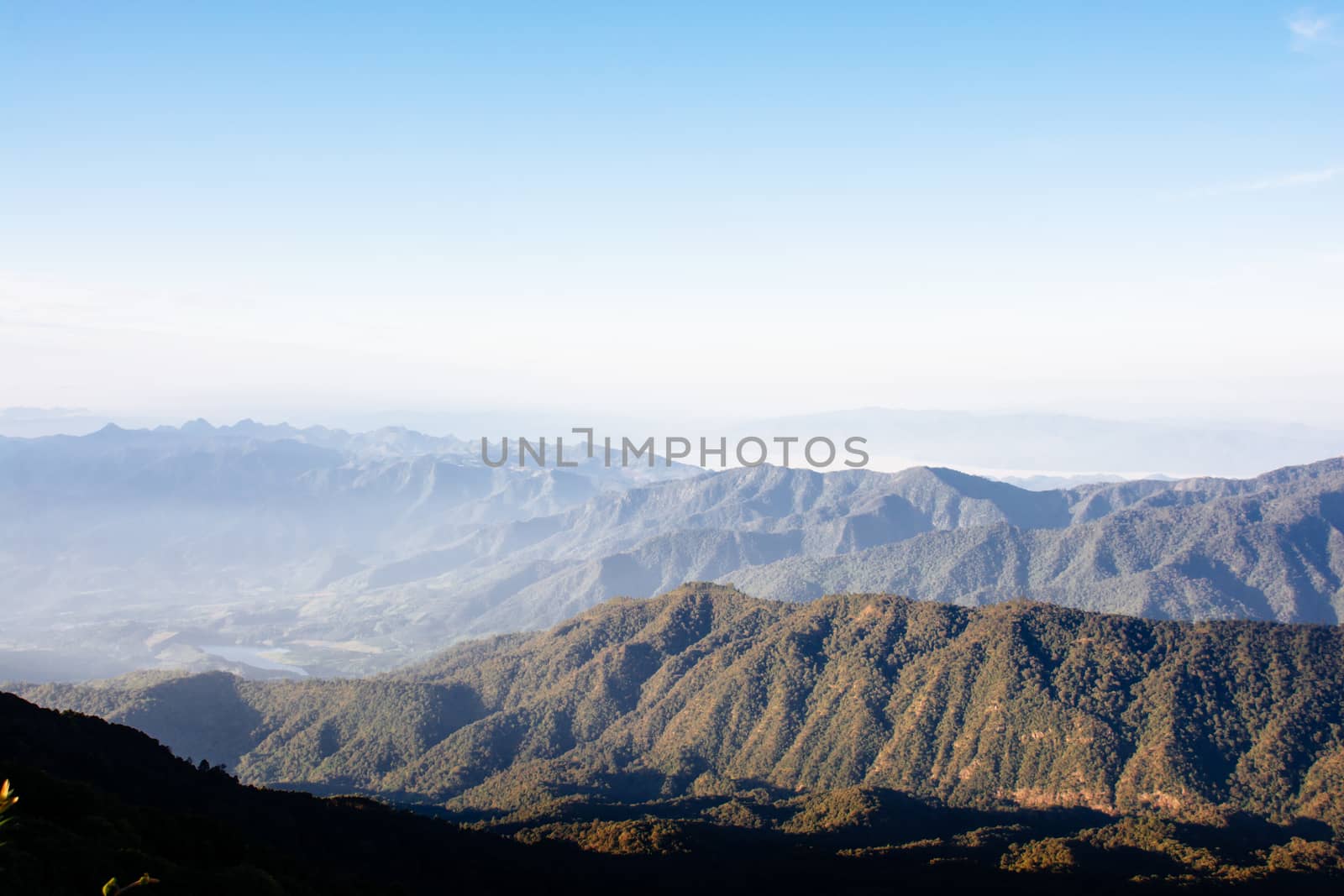 Mountain landscape in the fog with clear blue sky. by yuiyuize