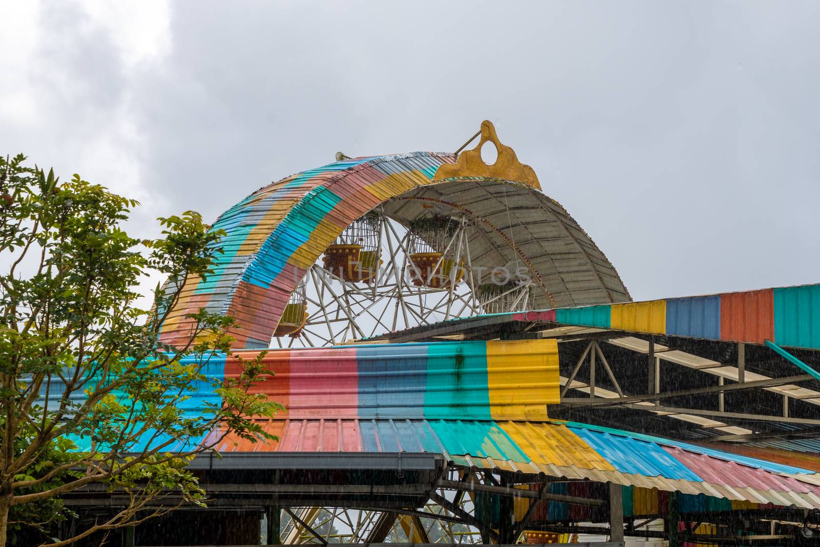 Amusement park old giant wheel colorful tin roof during heavy monsoon