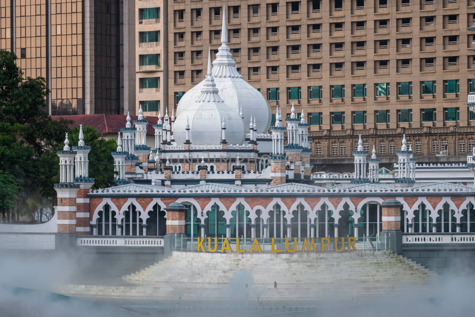 Masjid Jamek mosque in front of modern skyscraper in Kuala Lumpur by MXW_Stock