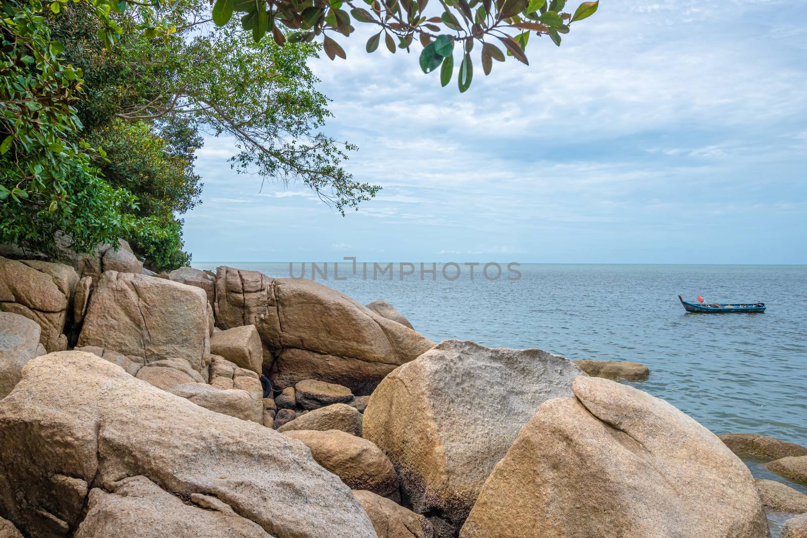Penang island rocks at beach next to the tropical rain forest of Penang National Park by MXW_Stock