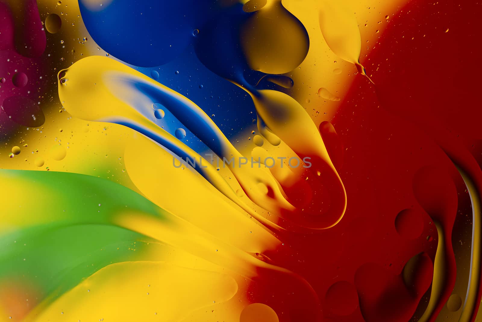 Abstract oil spots in motion on water on blurred yellow backgrou by alexsdriver