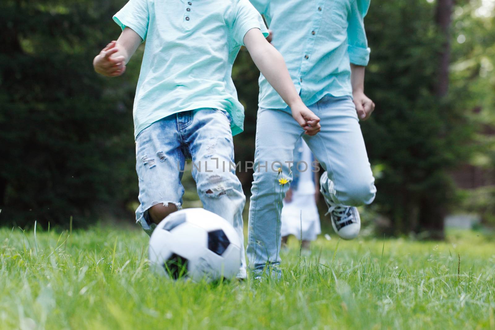 Happy children playing football in summer park