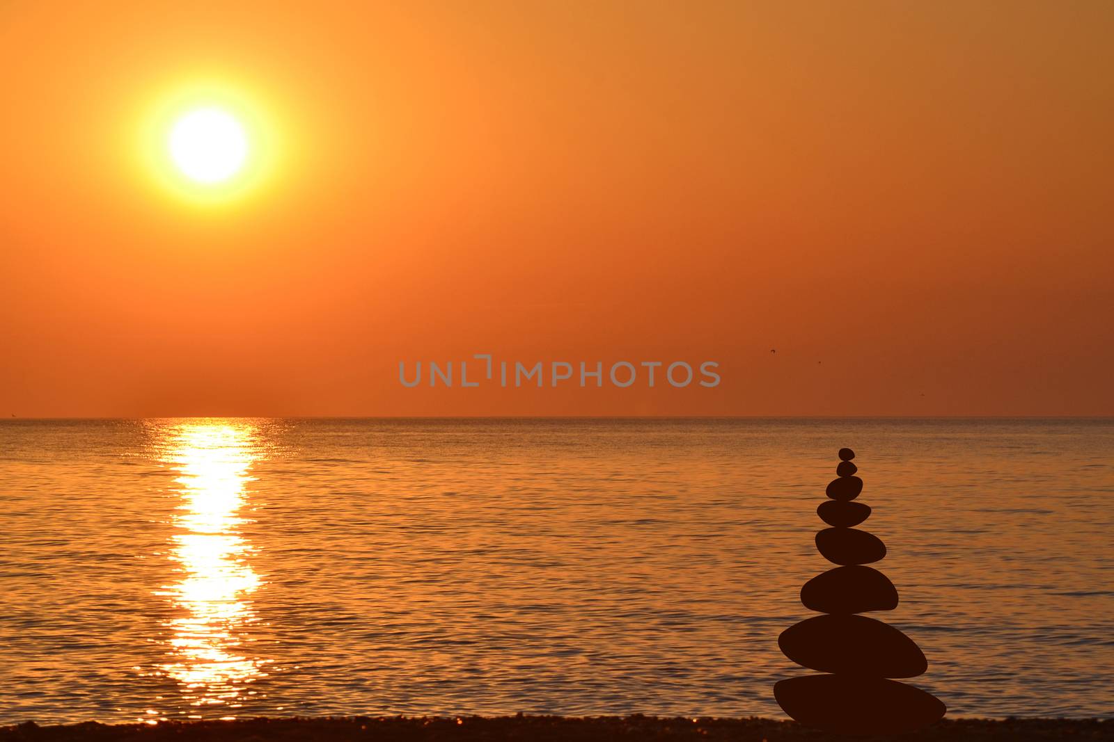 Relax zen stones balanced at sunrise at seashore