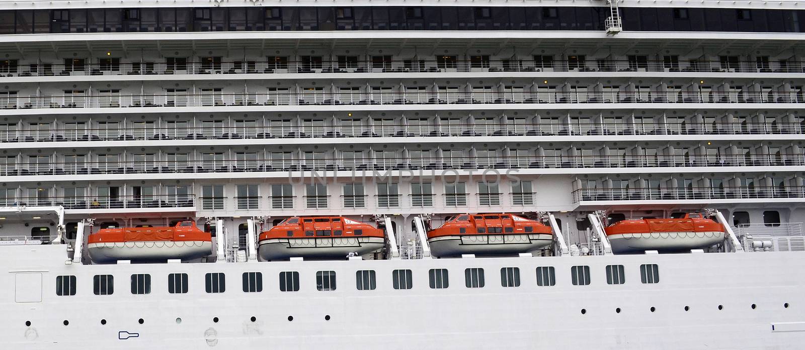 Side view of a cruise ship with lifeboats and cabins balcony