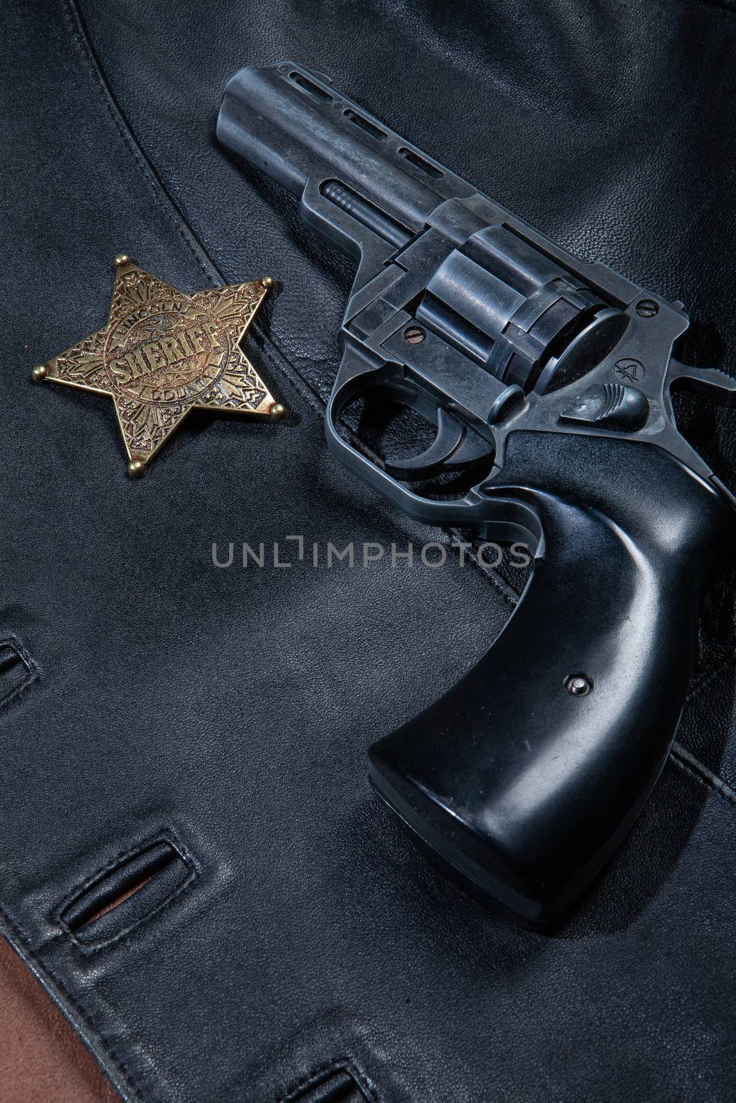 Star badge and revolver on a studio background