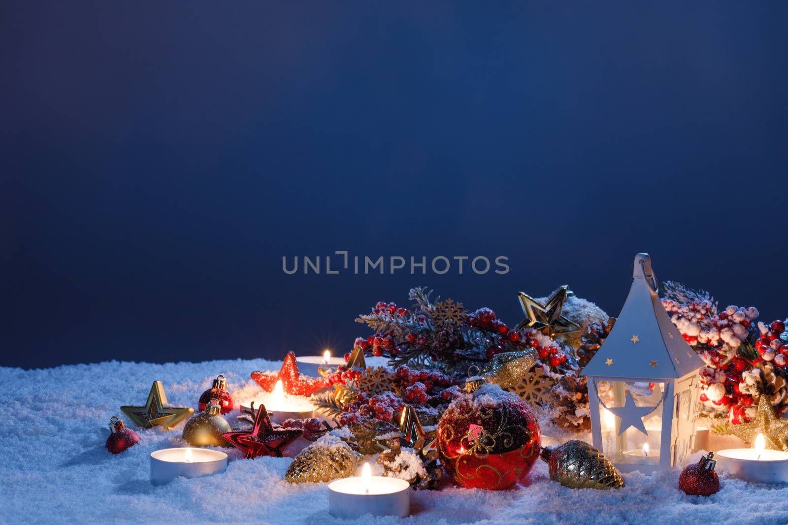 Christmas holiday card with decoration and glowing lantern in snow in the evening light
