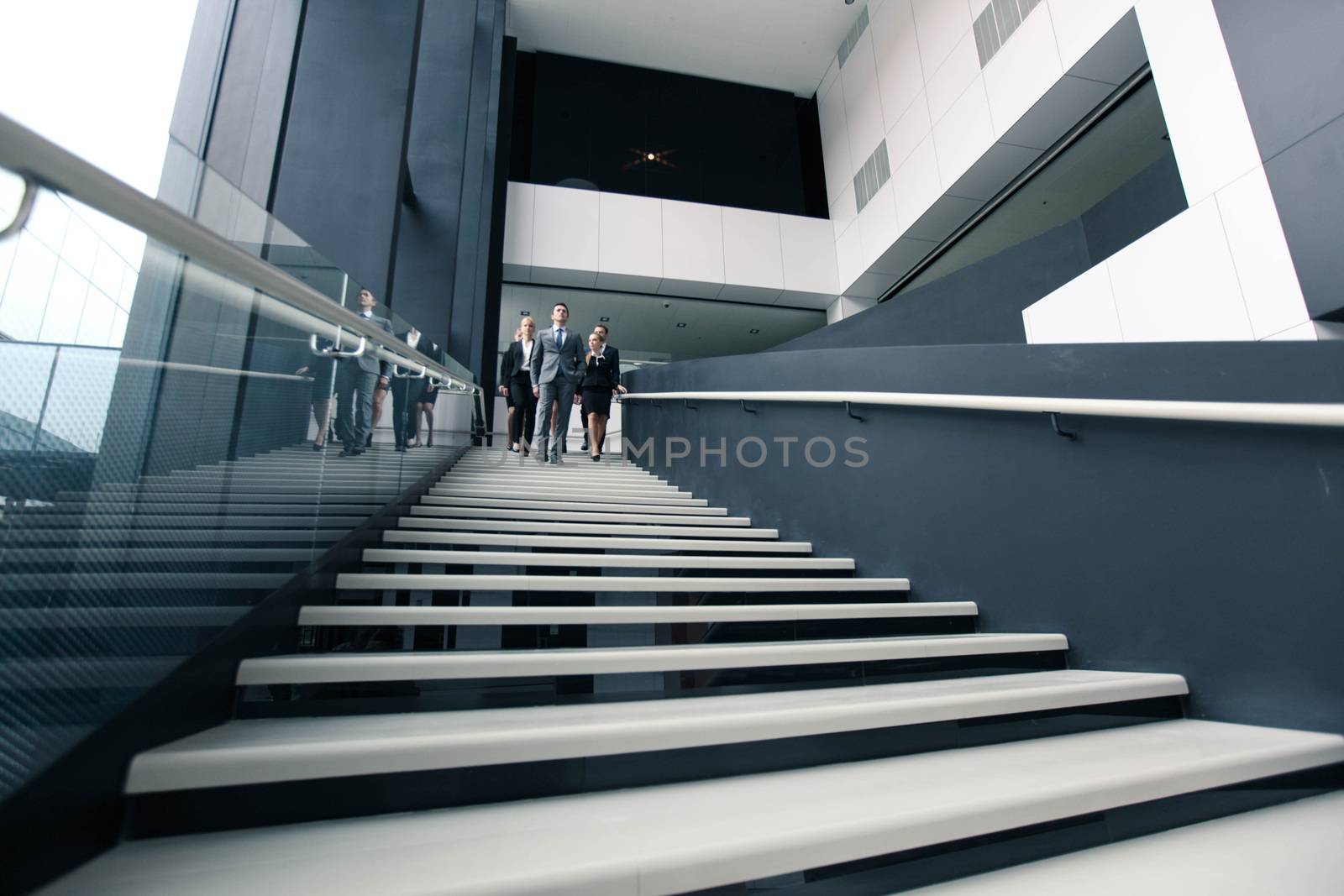 Group of Business people walking down stairs in office building