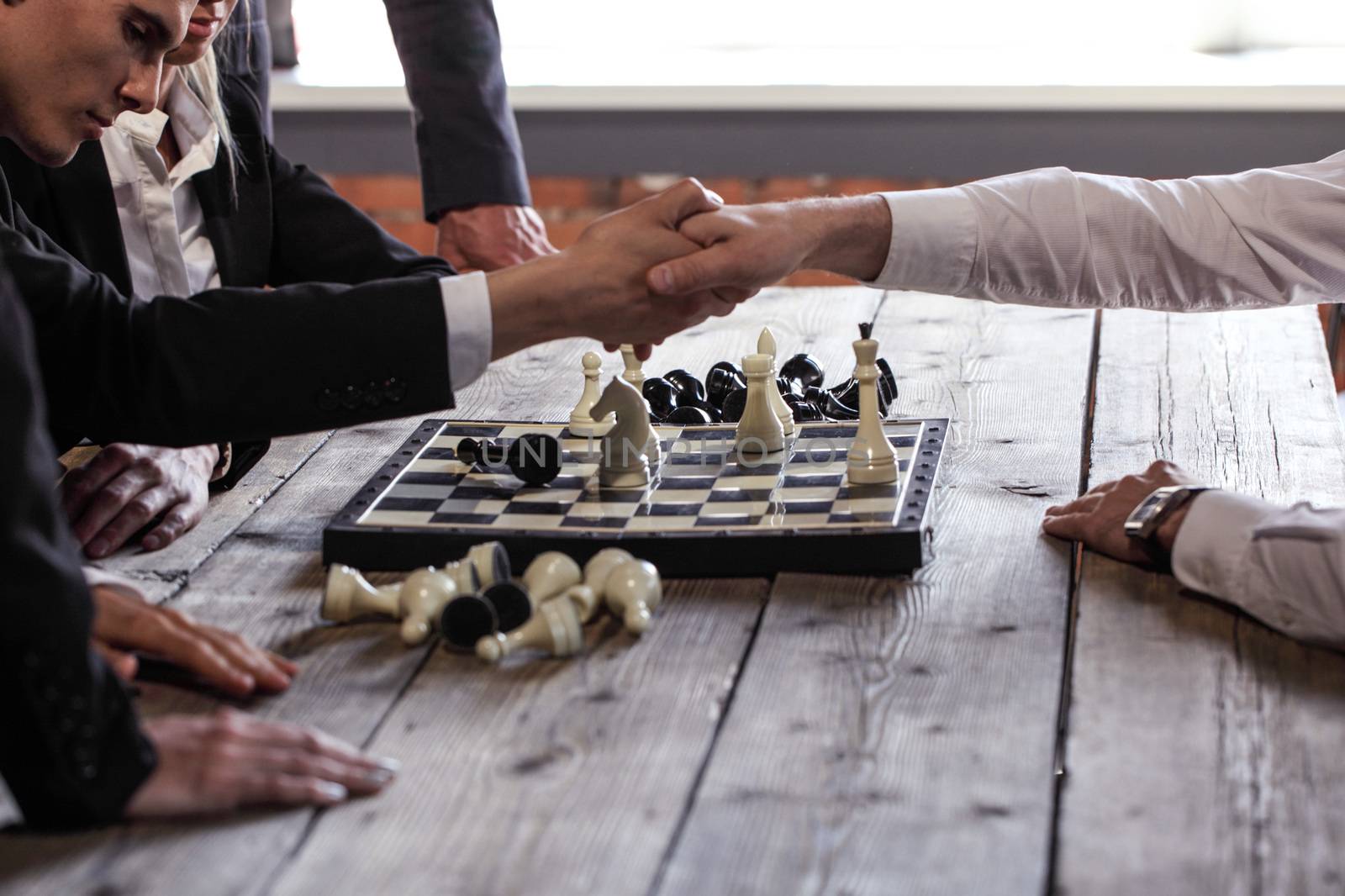 Businessman play chess and shake hands after the game