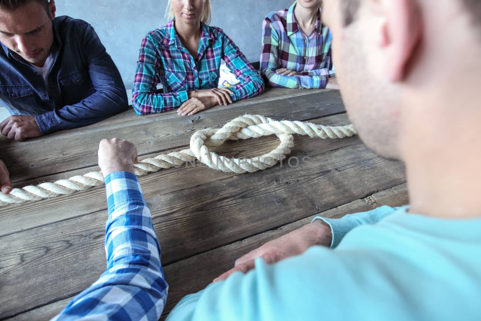 Business teamwork brainstorming planning meeting concept, people in casual clothes sitting around the table with rope node