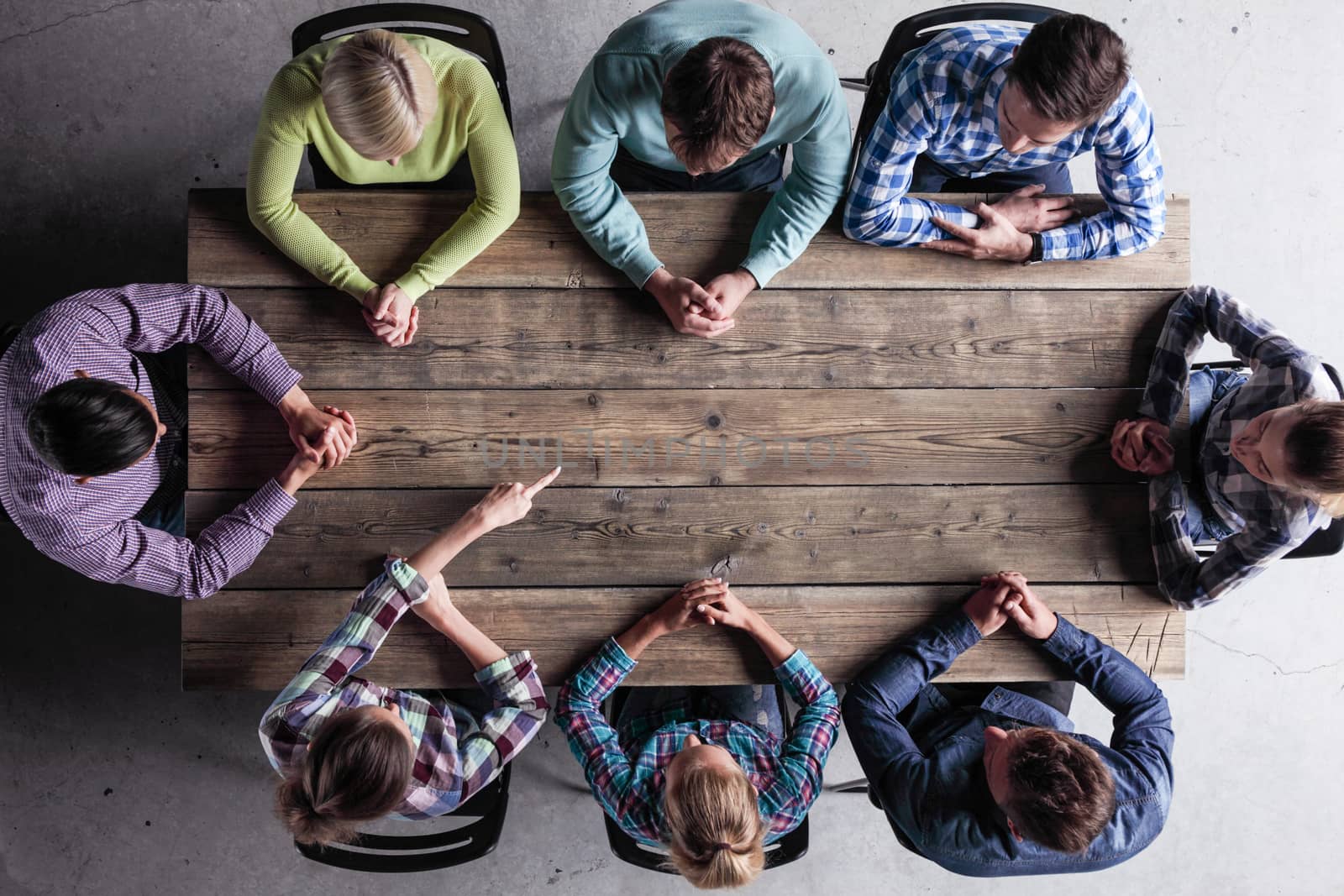 Hipster business teamwork brainstorming planning meeting concept, people team sitting around the table and pointing at copy space for text