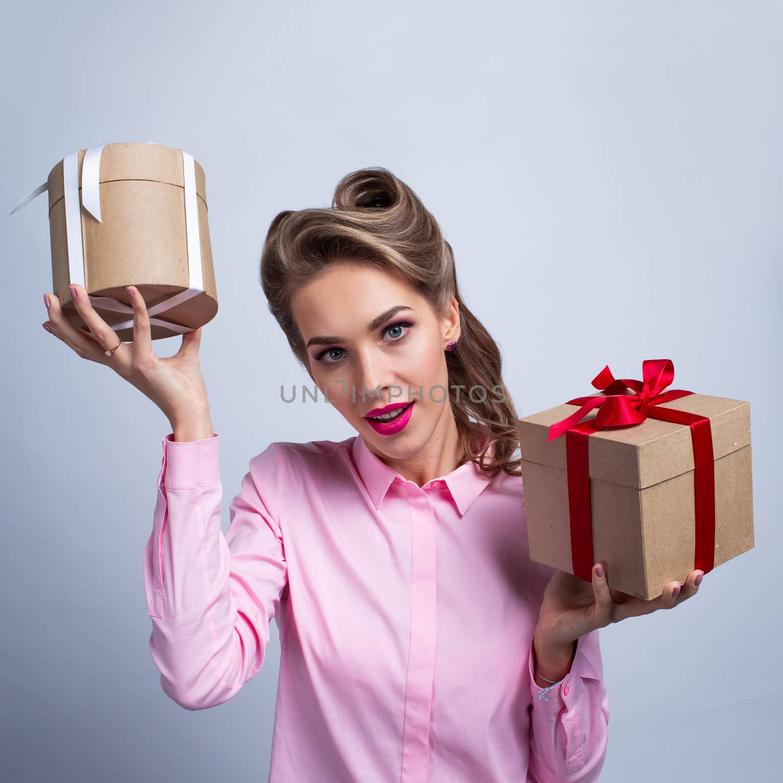 Beautiful young woman holding two holiday gifts