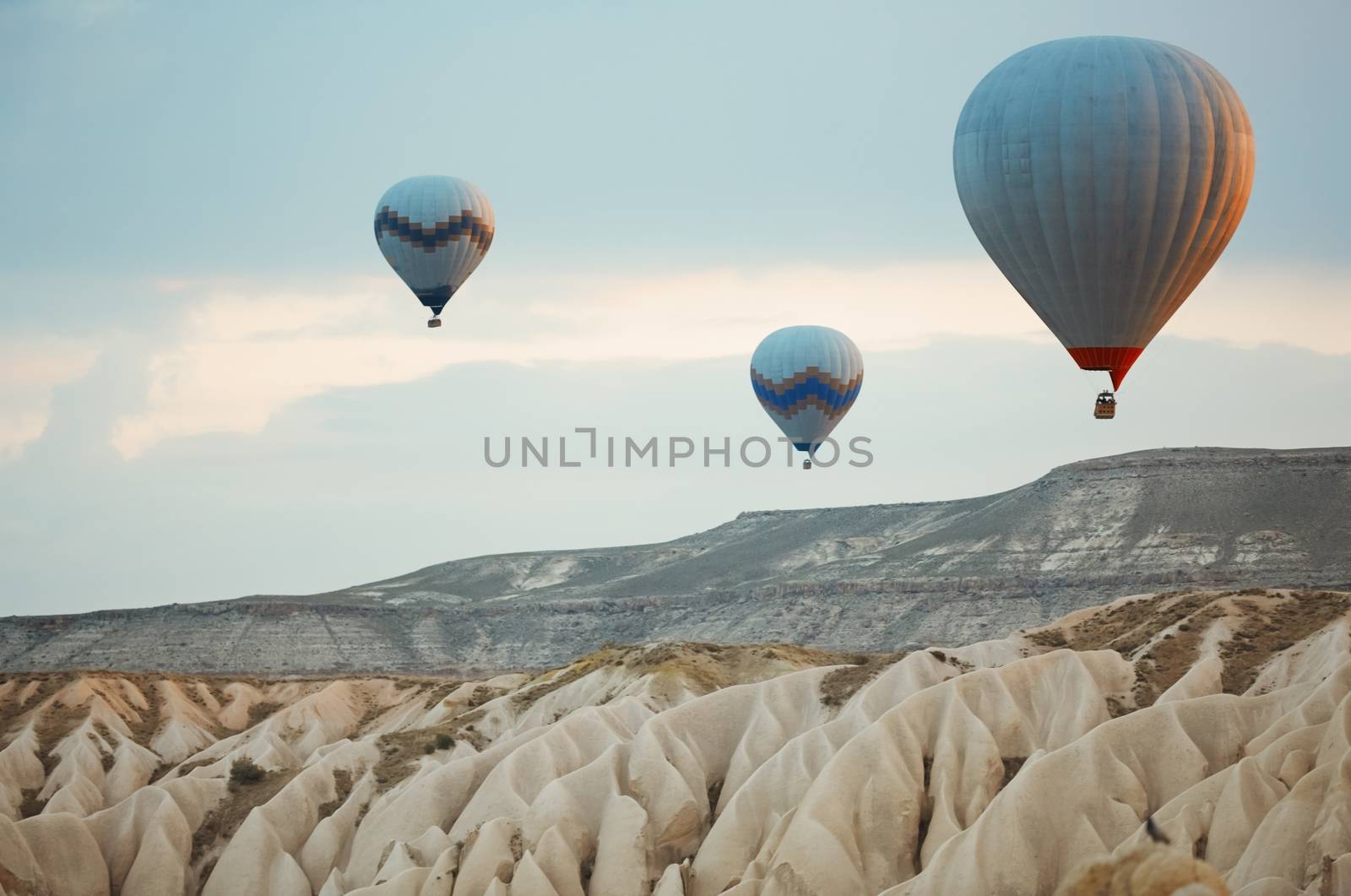 Three hot air balloons flying over the rocks of Cappadocia by Novic