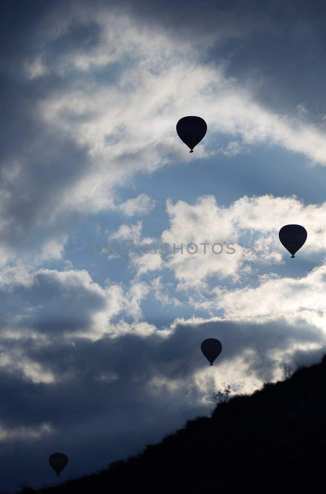 Silhouettes of the hot air balloons flying over the mountain