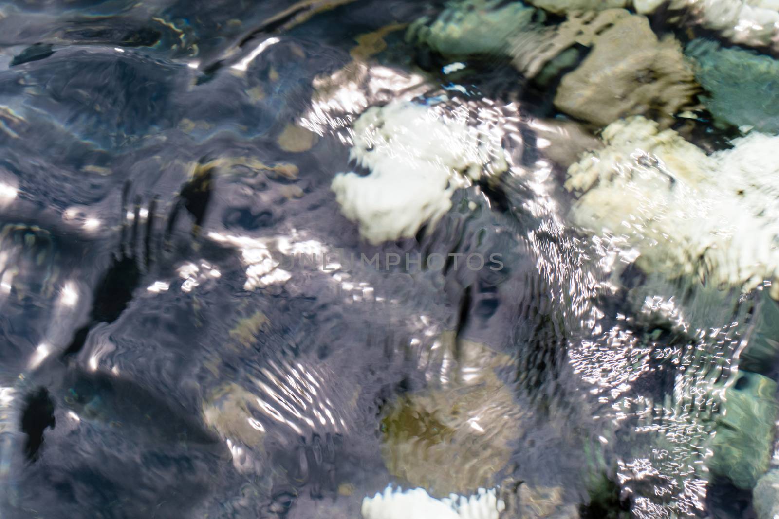 looking at the pebble stones in the water through wobbling surface