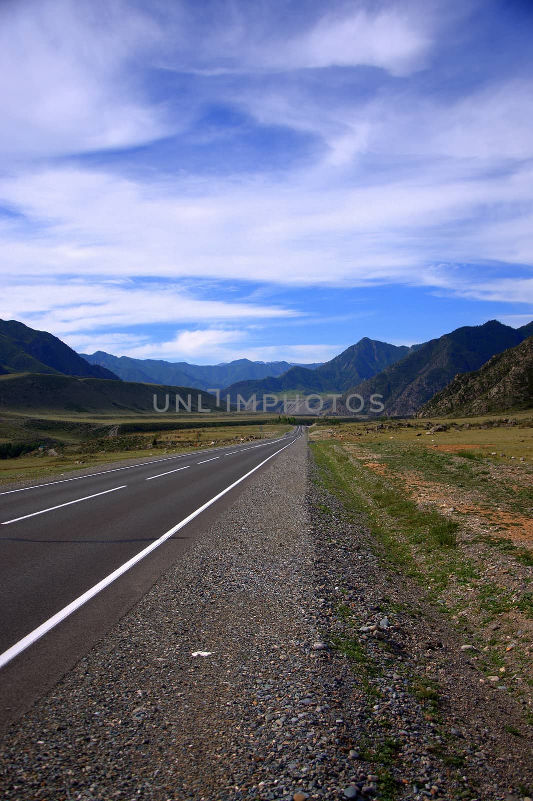 Beautiful asphalt road running in the intermontane hollow. Chuysky tract, Altai, Russia.
