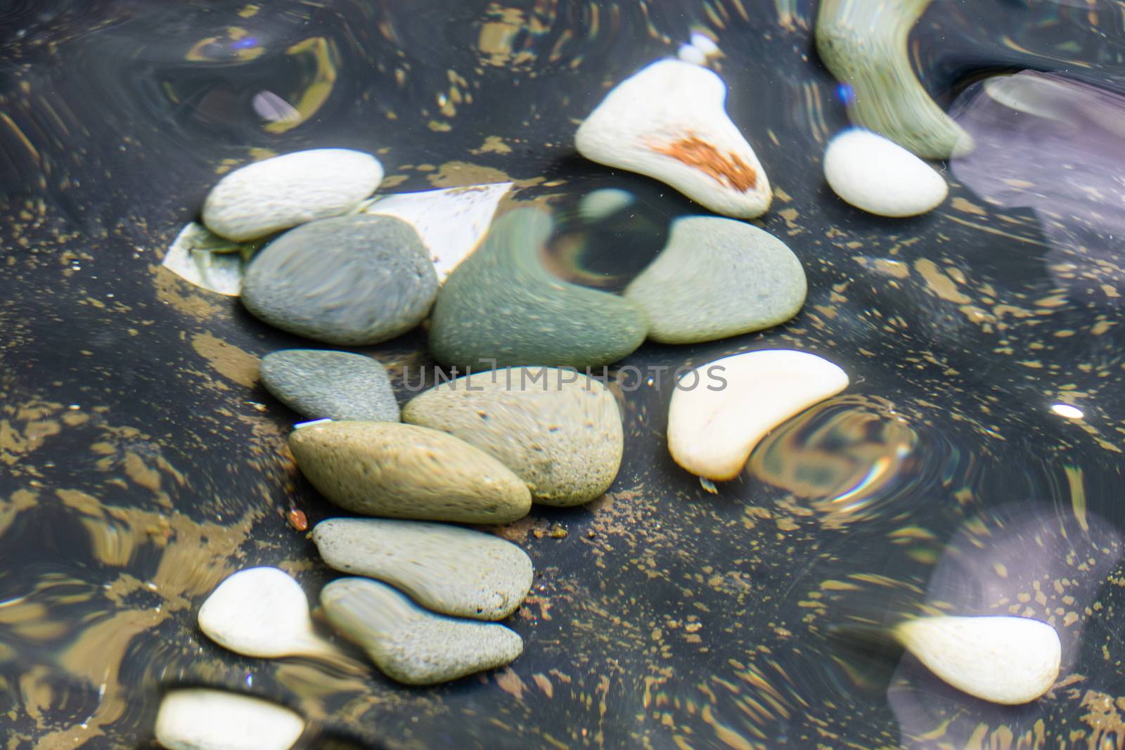 looking at the pebble stones in the water through wobbling surface