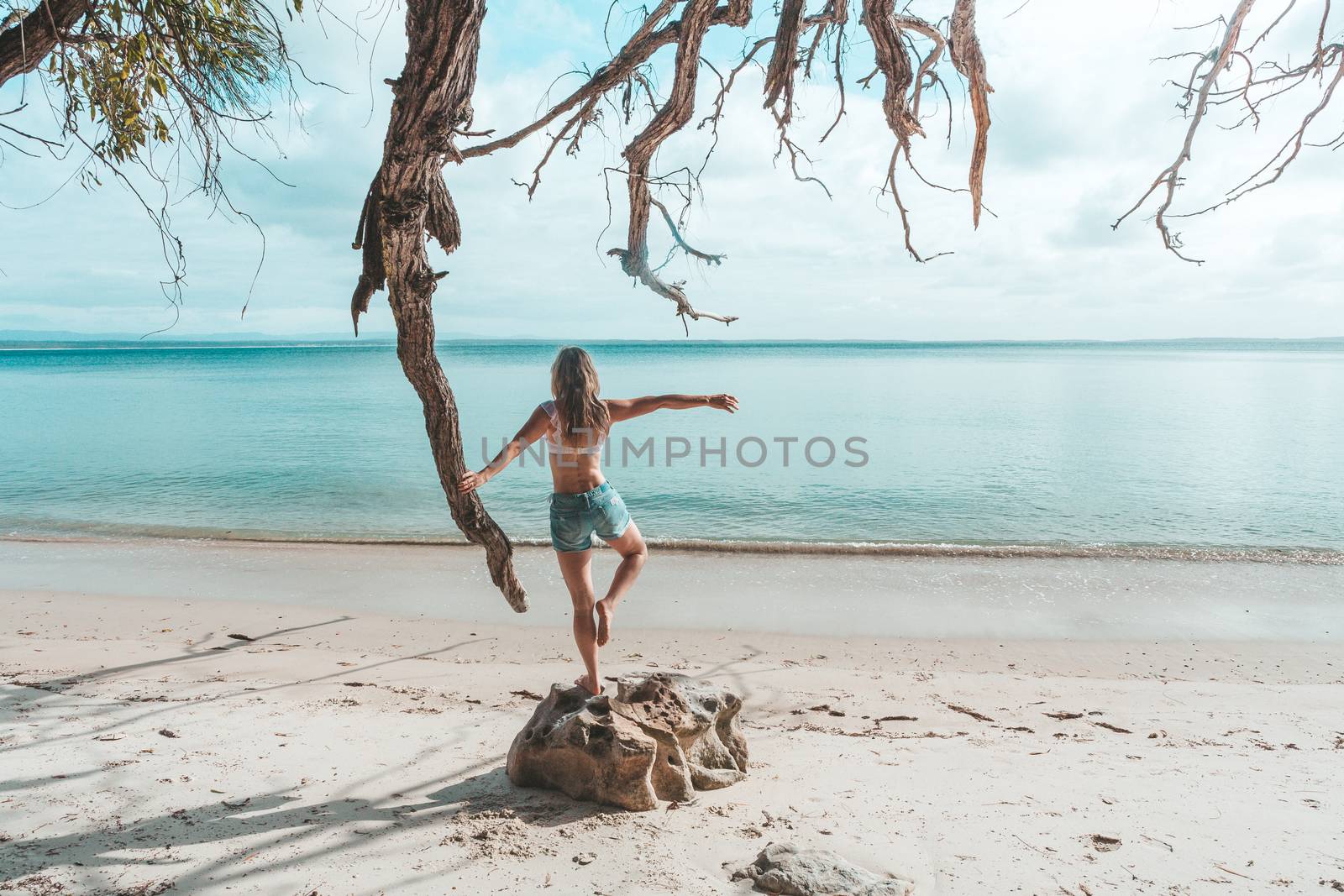 A female on an idyllic beach balancng on one leg in the warmth of the early light.  The morning is beautiful and the ocean is calm...., beach, holiday, weekend getaway, fun
