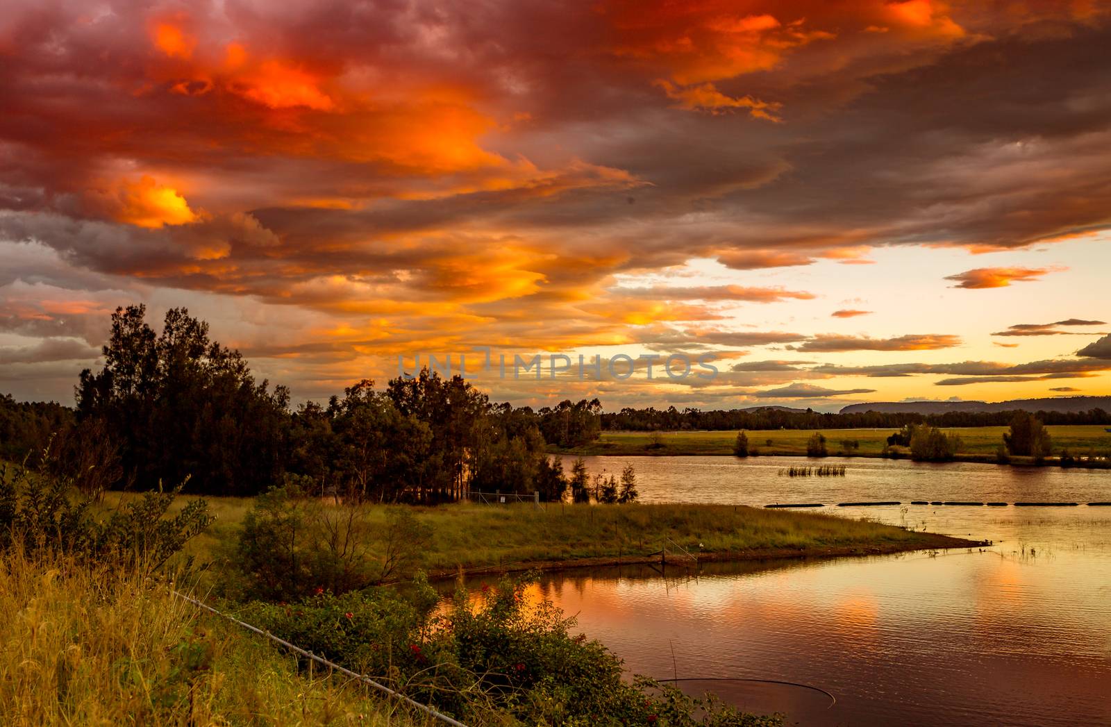 Sunset sky over rural lakes with mountain backdrop by lovleah