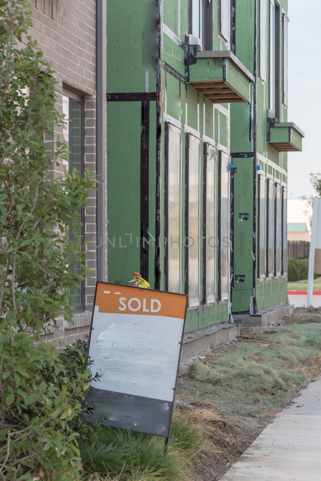 Front porch of modern house with Sold lawn sign near downtown Dallas, Texas. Brand new development urban house