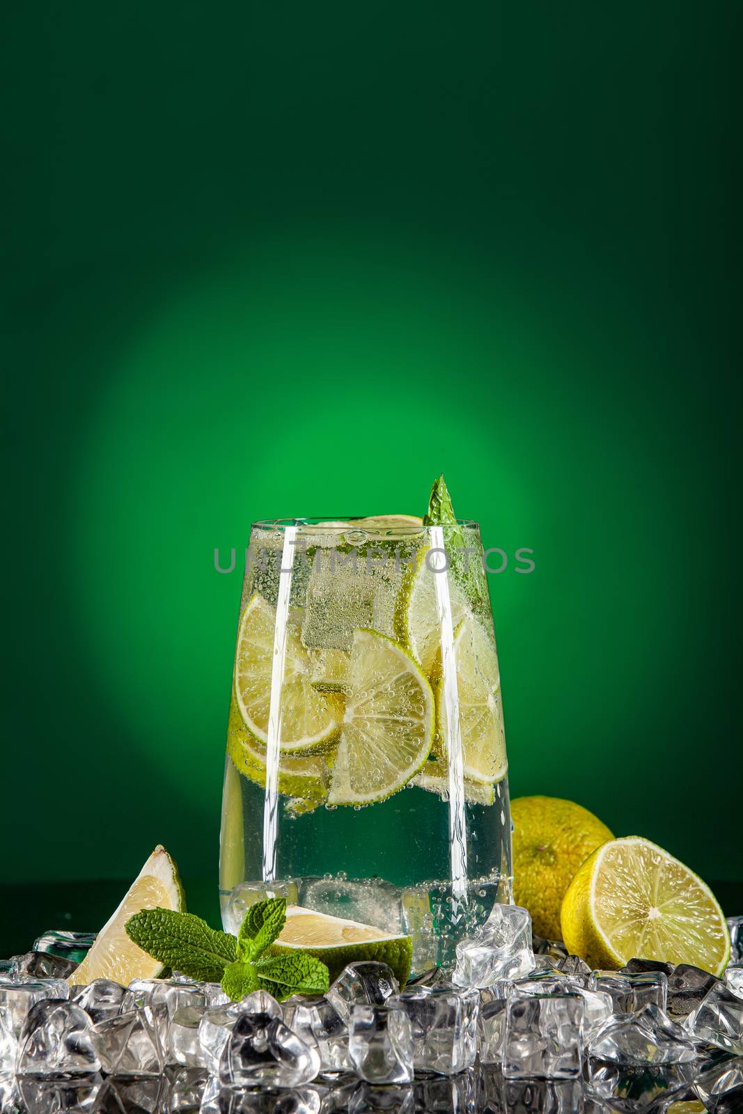 Glass of water, crystals of ice and lime